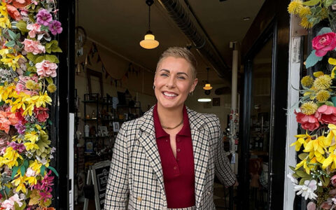 Owner of The Bend Mercantile, a downtown Tulsa small business, stands in the doorway of her shop.