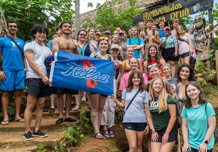 UTulsa students pose with a "Tulsa" flag during Jumpstart Panama
