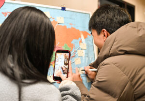 UTulsa students mark locations on a world map during international orientation.