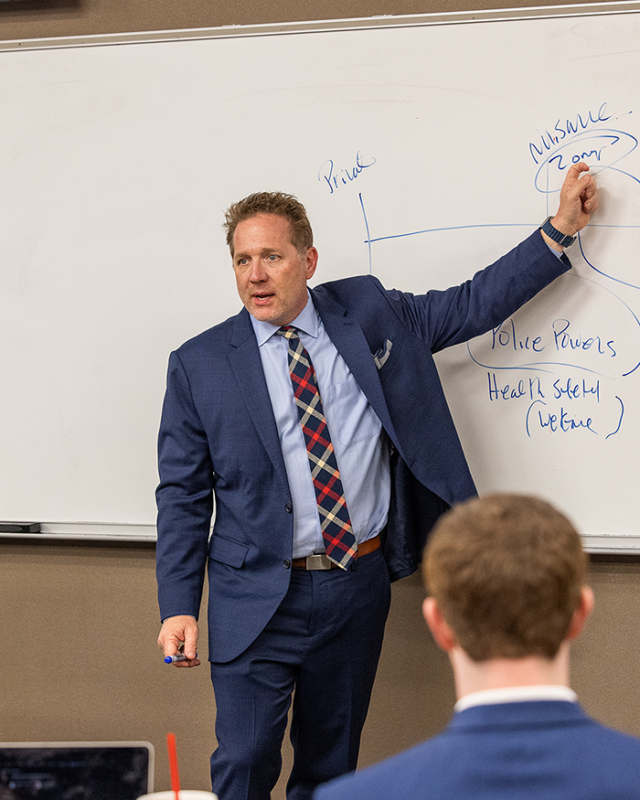 Law professor lecturing at whiteboard, March 2026.