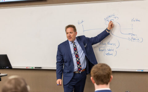 Law Dean lecturing with whiteboard diagrams in a classroom setting.