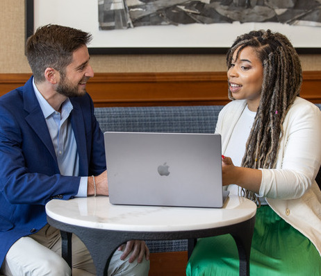 Two professionals collaborating on a laptop.