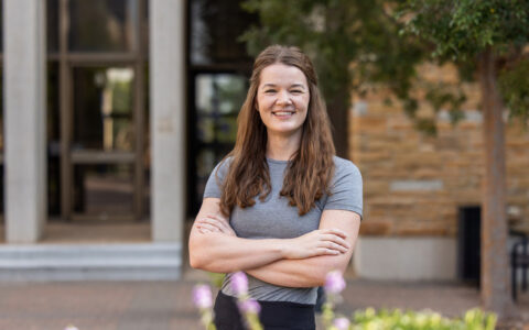 UTulsa Law alumna stands with arms crossed, smiling.