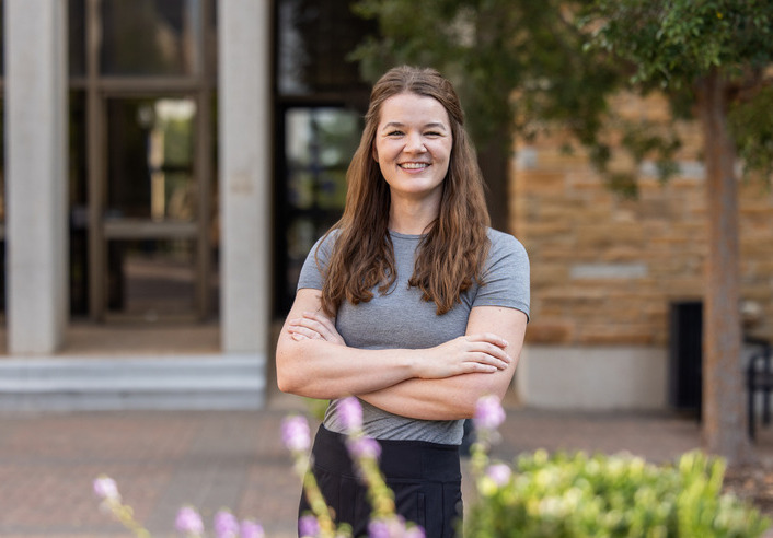 UTulsa Law alumna stands with arms crossed, smiling.