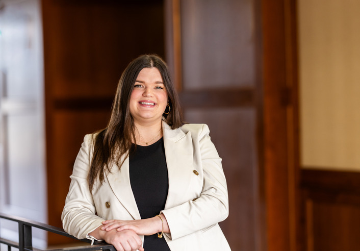 Professional woman in blazer, honoring Fern Holland's legacy.