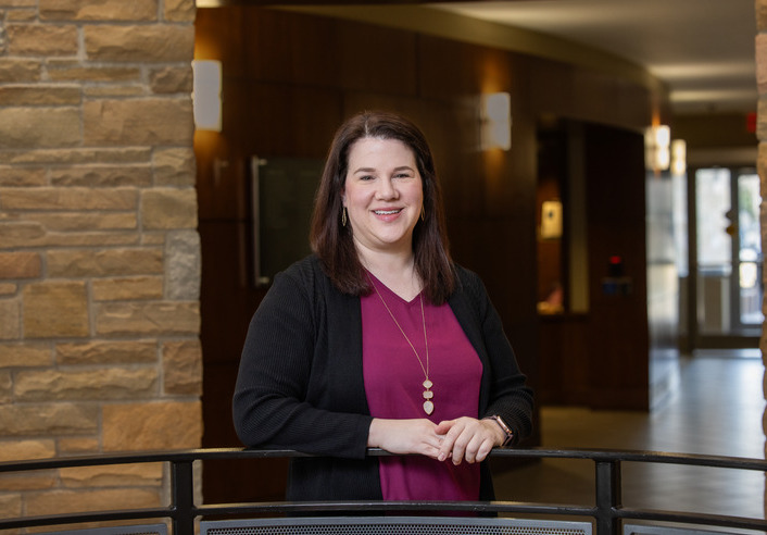 Portrait of a woman in a burgundy top and black cardigan