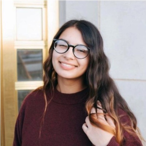 Smiling woman with glasses and long hair, OCII staff member.
