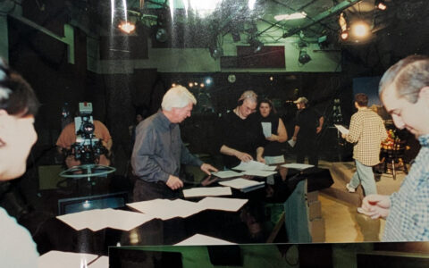 TUTV students on set with Moncrief, reviewing scripts and preparing for a broadcast.