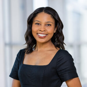 Smiling Black woman in black dress. Law Admission. 
