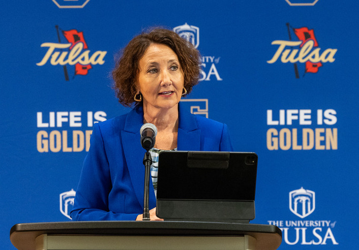 President-elect Stacy Leeds speaks at The University of Tulsa. "Life is Golden" is in the background.