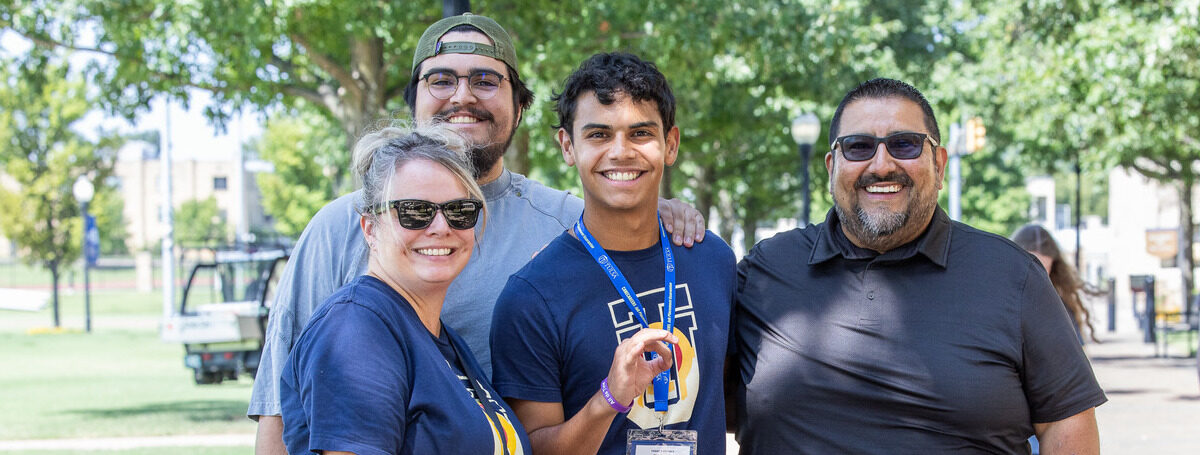 Family smiling on UTulsa campus