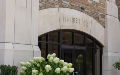 Helmerich building entrance with lush green hydrangea bush