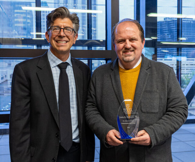 Justin Hathaway inducted into Communications Hall of Fame, holding award