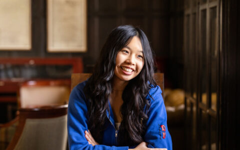 Abigail Chow, UTulsa alumna and fintech founder, smiling in a wood-paneled room.