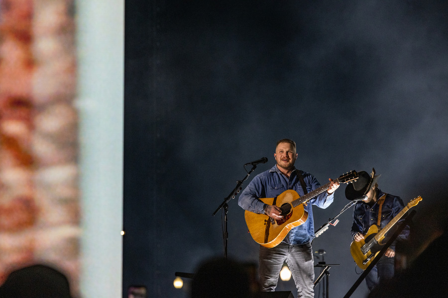 Zach Bryan performing live at a 2026 concert in Tulsa.