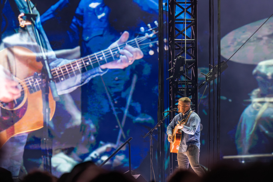 Zach Bryan performing live with guitar at 2026 concert.
