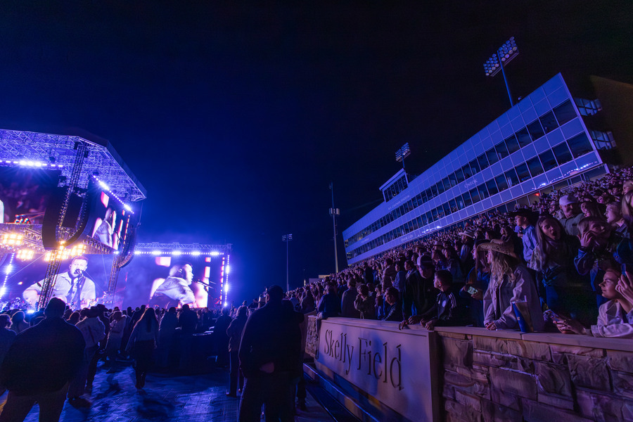 Zach Bryan concert at Skelly Field: Large crowd, stage lights, and video screens.