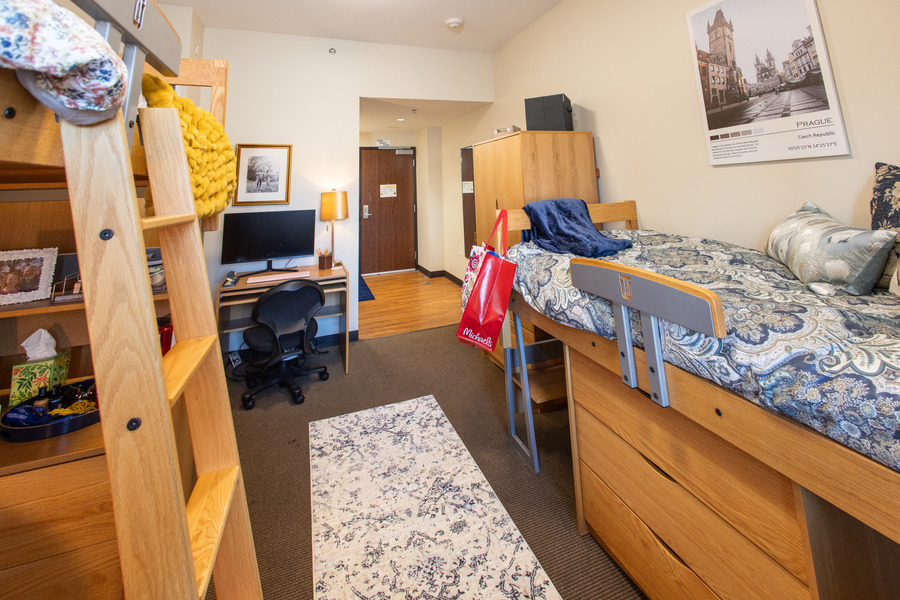 Hardesty Hall dorm room with lofted beds, desk, and Prague poster.