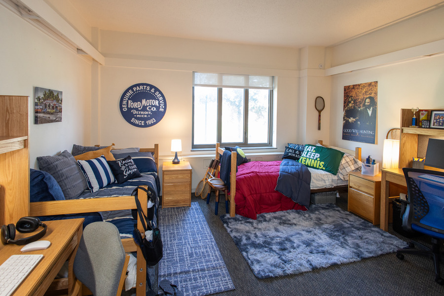 Dorm room in John Mabee Hall with two beds, desks, and Ford Motor decor.