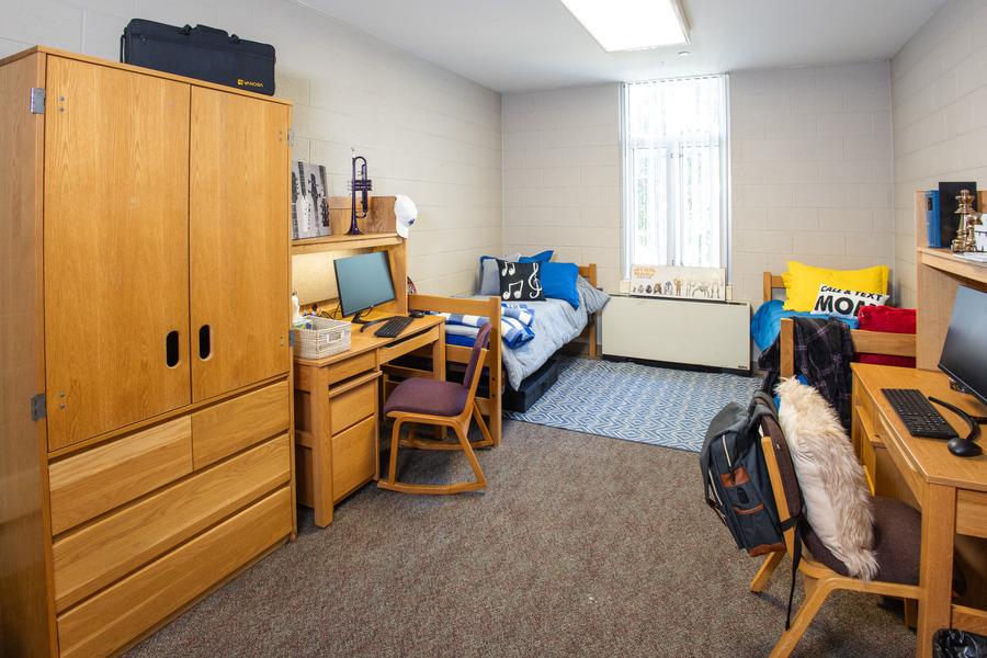 Utulsa LaFortune House dorm room with beds, desks, and wooden furniture.
