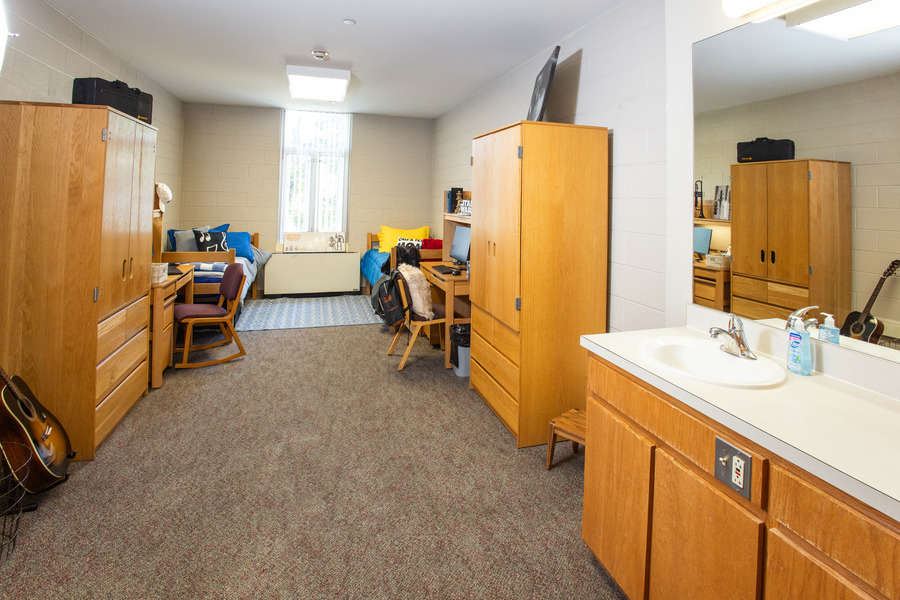 UTulsa LaFortune House dorm room with beds, desks, and wardrobes.