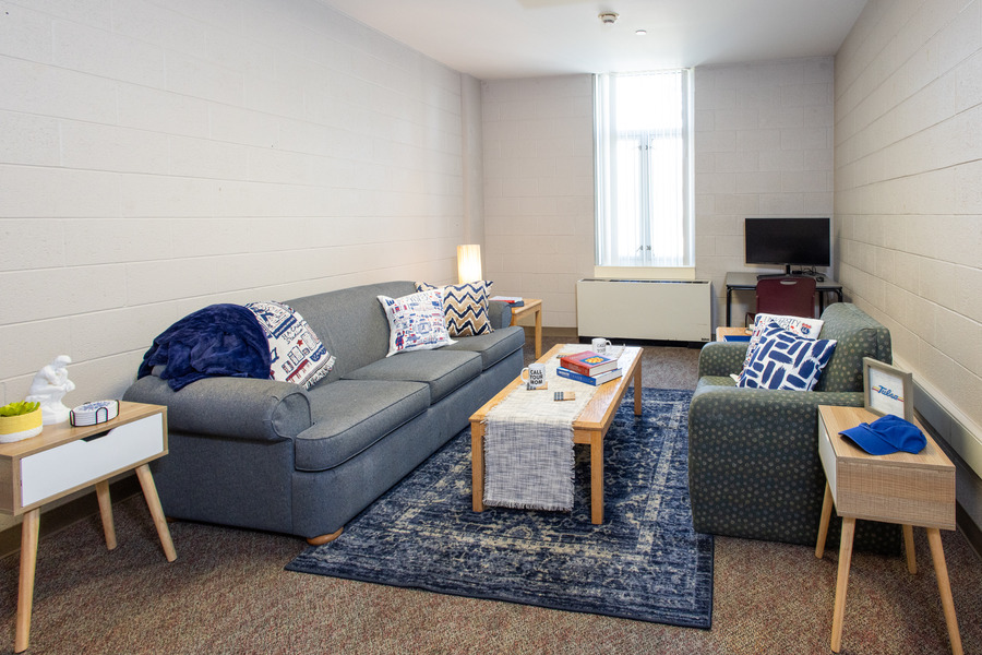 LaFortune House living space at UTulsa: couch, chair, rug, and desk.