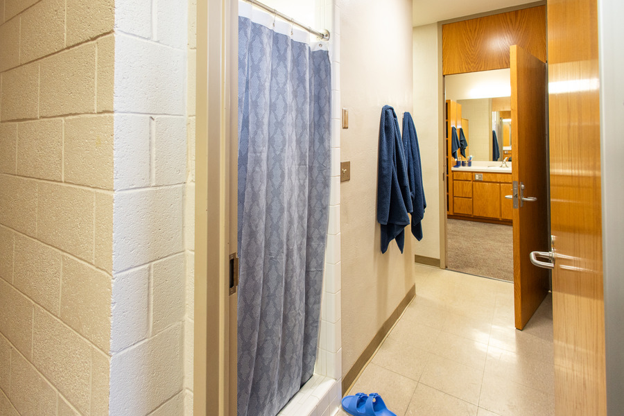 UTulsa LaFortune House dorm room interior with shower, towels, and open bathroom door.