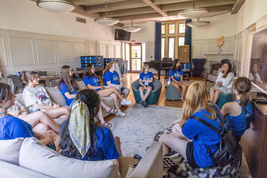 Students gather in Lottie Jane Mabee Hall lounge, listening to a speaker.