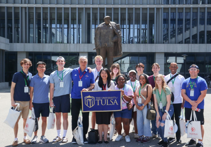 Group photo at The University of Tulsa with Vice Provost Vivian Wang holding a sign.