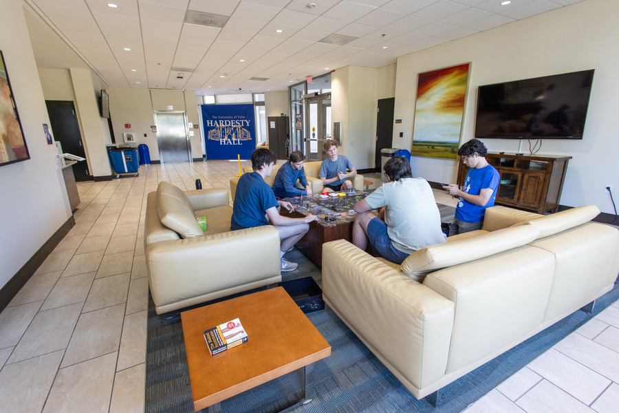Students gather in Hardesty Hall lounge playing a board game.