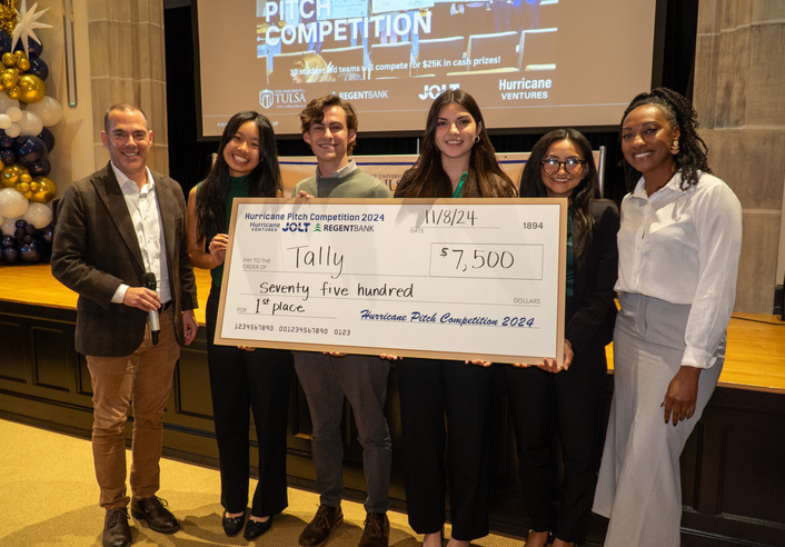 Team Tally wins the Hurricane Pitch Competition 2024, holding a $7,500 check.