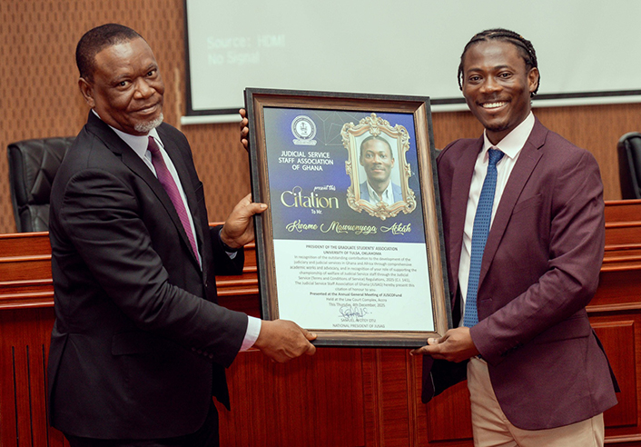 Two men hold a citation award for Kwame Marunyege Asare from the Judicial Service Staff Association of Ghana.