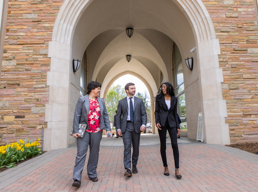 Law students walking through an archway on campus