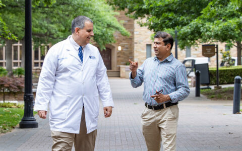 TU Tulsa brain health researchers discuss Alzheimer's research outdoors.