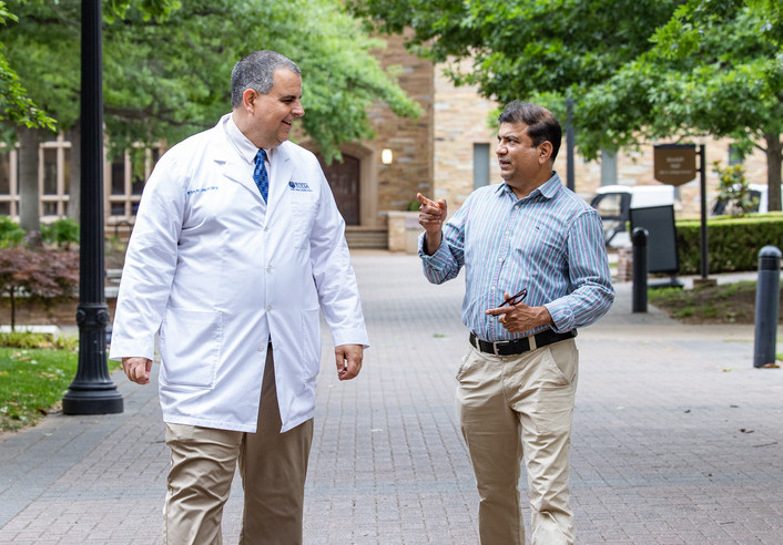 TU Tulsa brain health researchers discuss Alzheimer's research outdoors.