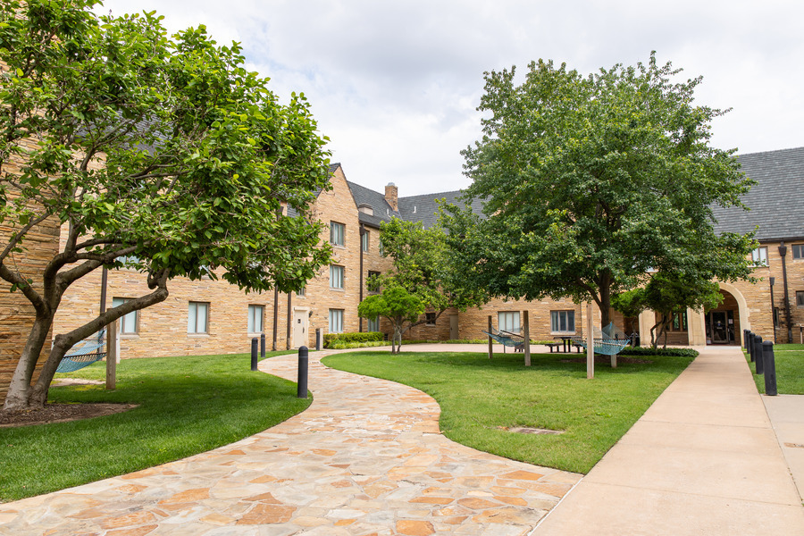 Lottie Jane Mabee Hall courtyard with stone path, trees, and hammocks