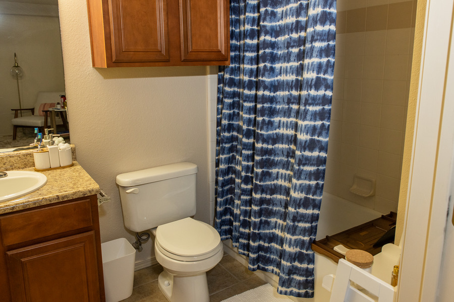 Bathroom at Mayo Village with blue tie-dye shower curtain and toilet.