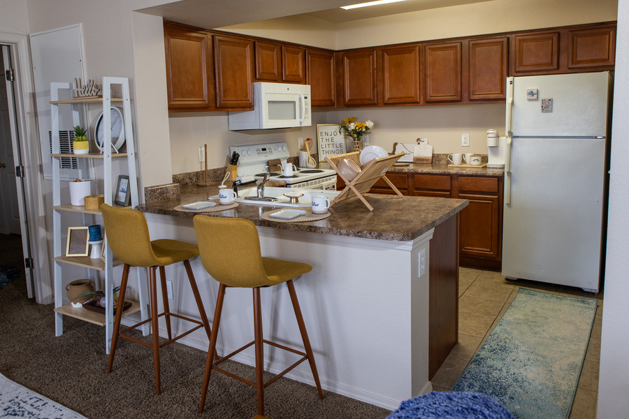 Mayo Village kitchen with island, bar stools, and stainless steel refrigerator.