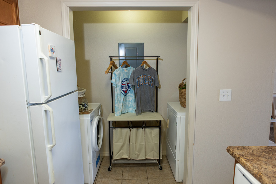 Mayo Village laundry area with washer, dryer, and clothes rack.