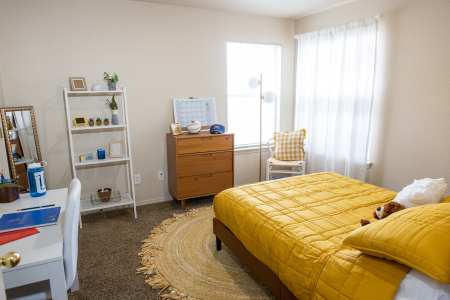 Mayo Village dorm room with yellow bedding, desk, and dresser.
