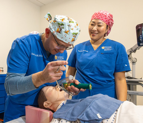UTulsa grad students practice intubation on a medical dummy in a simulation lab.