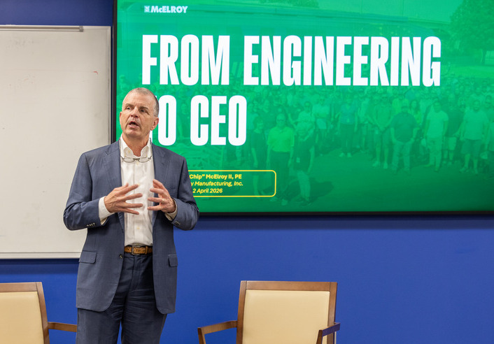 Chip McElroy, CEO of McElroy Manufacturing, speaks at UTulsa in front of a screen with a slideshow titled "from engineering to ceo"