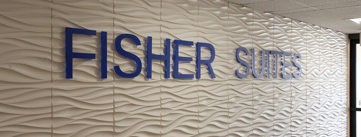 Fisher Suites sign on a textured wall, UTulsa housing