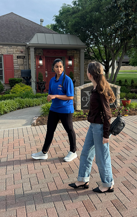 Graduate student ambassador and visitor walk outside of Greek houses at UTulsa.