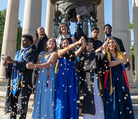 Group of graduates celebrate commencement with confetti toss