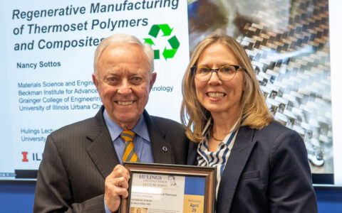 Jim Brill and Nancy Sottos holding a framed document while smiling