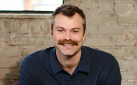 Photograph of Will Gray, a smiling person with a mustache