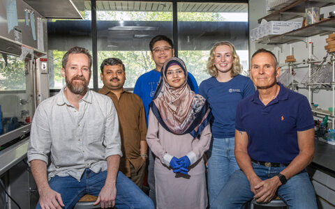 Chemistry researchers, recipients of NSF grant, pose for a group photo in a lab.