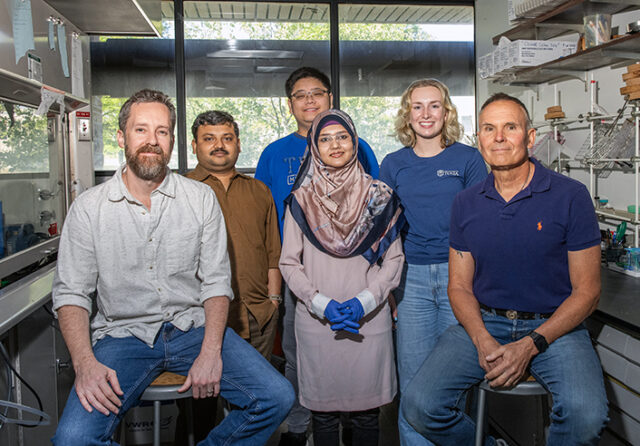 UTulsa chemistry faculty and student researchers smile for a photograph in their science lab