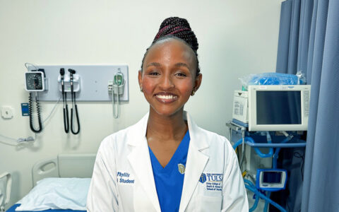 Phyllis Ekwempu, a nursing student at The University of Tulsa, smiles in a hospital room.